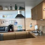 Küche mit Holzschränken, Herd, Spüle und Küchengeräten.