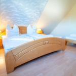 Schlafzimmer mit Doppelbett und kleinem Bett unter schrägem Dach