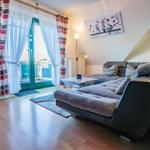 Wohnzimmer mit Sofa, Couchtisch und Balkontür mit Blick.