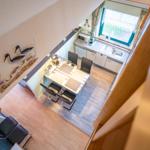 Küche und Essbereich mit Tisch, Stühlen und Fenster. Wanddekoration mit Vogelmotiven.