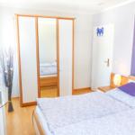 Schlafzimmer mit Doppelbett, Kleiderschrank und Fernseher.