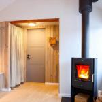 Room with fireplace, wood wall, and door with curtain.