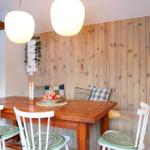 Dining room with wooden wall, table, chairs, and side table.