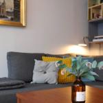 A gray sofa with cushions and a table with flowers.