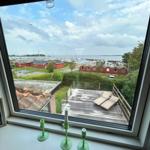 From the window, you can see a terrace with loungers and a harbor with boats.