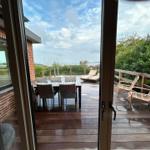 Deck with table, chairs, and loungers. View of sea and boats.
