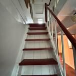 Staircase with red steps and white walls. Handrail and ceiling are visible.