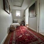 Bedroom with bed, rug, and wall art. Window and door are visible.