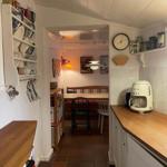 Kitchen with wooden countertop and dining area in the background.