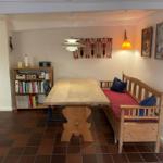 Dining room with wooden table, bench, and bookshelf against the wall.
