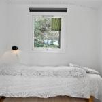 Schlafzimmer mit Bett, Fenster und Lampen.