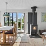 Essbereich mit Tisch und Stühlen, Kamin und Blick auf den Garten.