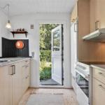 Küche mit Holzmöbeln, Arbeitsfläche und Tür zum Garten.