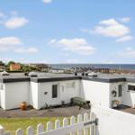 Wohnung mit Blick auf Meer und Strand. Außenbereich mit Tisch und Bank.