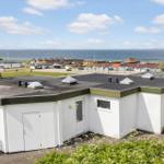 Wohnung mit Blick auf Meer und Strand. Weiße Fassade, Terrasse und Garten.