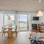 Wohn- und Essbereich mit Blick auf Balkon. Holzdecke, TV und Sitzgelegenheiten.