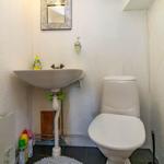 Badezimmer mit Waschbecken, Toilette und Spiegel an der Wand.