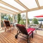 Terrasse mit Sitzgelegenheiten und Blick auf einen See.