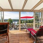 Terrasse mit Blick auf See, rote Liege und Sonnenschutz