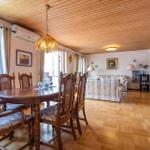 Esszimmer mit Holztisch und Stühlen. Wohnbereich mit Sofa und Holzboden.