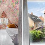 Schlafzimmer mit floraler Tapete und Blick auf eine Straße mit Häusern.