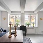 Wohnzimmer mit Sofa, Tisch, Fenstern und Balken an der Decke.