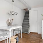 Essbereich mit Tisch, Stühlen und Steintreppe zur oberen Etage.