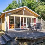 Ein gelbes Haus mit Terrasse und Sitzgelegenheiten im Grünen.