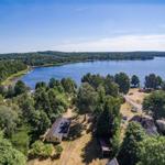 Haus am See mit Wald und freiem Blick auf das Wasser.