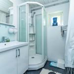 Badezimmer mit Dusche, Waschbecken und Fenster