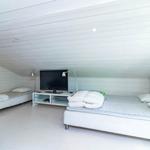 Zimmer mit zwei Betten, Fernseher und Lampe an der Wand.