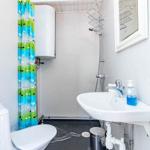 Badezimmer mit Dusche, Waschbecken und Toilette. Farbiger Duschvorhang und Spiegel.