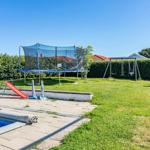 Poolbereich mit Trampolin, Rutsche und Schaukel im Garten.