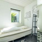 Schlafzimmer mit Bett, Fenster und Wanddekoration.