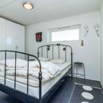 Schlafzimmer mit Bett, Kleiderschrank und Fenster.