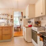 Küche mit Holzschränken, Kochfeld und Blick in das Esszimmer.