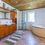 Bad mit Holzdecke, Badewanne, Dusche und Waschbecken mit Holzschrank.