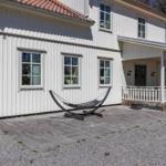 Haus mit weißer Fassade, Terrasse und Hängemöbel im Vorgarten.