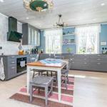 Küche mit grauen Schränken, Holzfußboden und Essbereich mit Tisch.