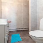 Badezimmer mit Waschbecken, Toilette und Dusche. Blauer Teppich auf dem Boden.
