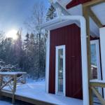 Rotes Haus mit Schneebedeckter Terrasse und Wald im Hintergrund.