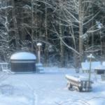 Schneebedeckter Hot Tub im Wald mit Gartenmöbeln und Bäumen.