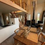 Esszimmer mit Holztisch, Küchenbereich und Aufgang zur Galerie