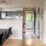 Küche mit Essbereich und Wohnbereich mit Holzwand und -decke.