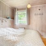 Schlafzimmer mit Holzwand, Bett, Fenster und Hängeregler.