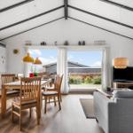 Wohn- und Essbereich mit Holztisch, Sofa und Terrassentür.