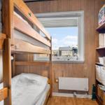 Ein Schlafzimmer mit Kletterwand und Fensterblick auf die Umgebung.