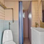 Bathroom with toilet, sink, and shower with curtain.