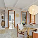 Dining area with round table, chairs, and large lamp. Picture on wall. Bookshelves on the left.