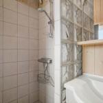 Bad mit Dusche, Waschbecken und Glasblockwand
